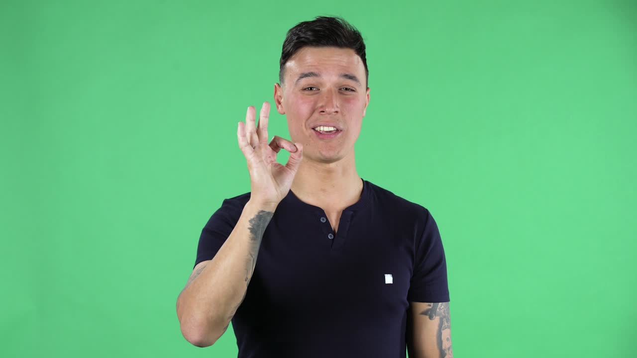 잘생긴 젊은 남자의 초상화가 카메라를 바라보고 ok 표지판을 만들고 있습니다.