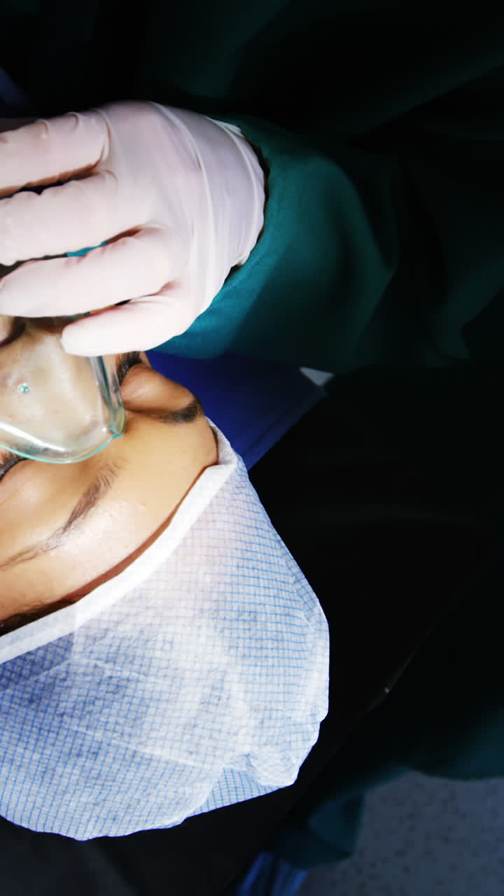 cirujano poniendo una máscara de oxígeno en el paciente en la sala de operaciones