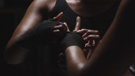 studio shot of women putting on boxing wraps on hands before exercising together 2