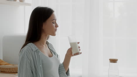 pregnant woman drinking milk in the kitchen