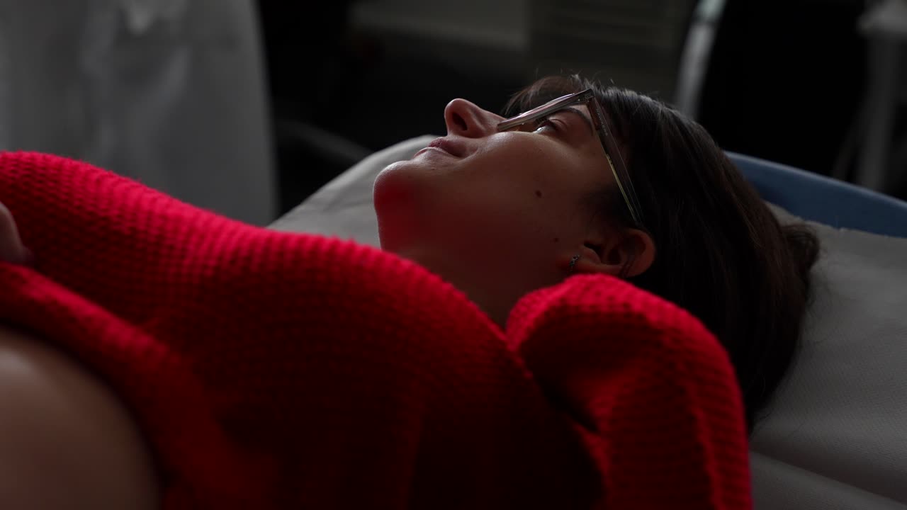Pregnant woman lying on a stretcher smiling during checkup in hospital. Close up