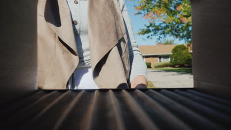 a young woman with a small dog in her arms picks up letters from a mailbox