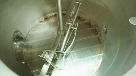 craft beer production factory, brewery manufacture. putting barley malt grains in conveyor close-up. brewing, cooking alcohol in metal vats bottles