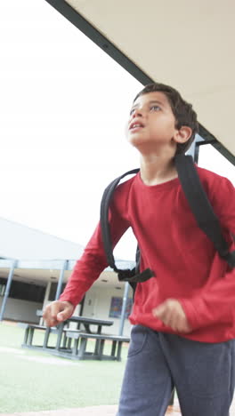 vertical video: in a school setting, a young biracial student is captured mid-stride