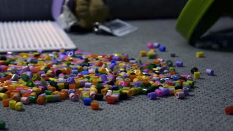 child making art with perler beads,on the sofa