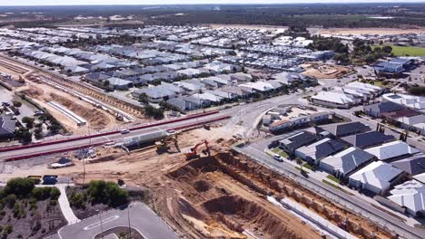 Vista-Aérea-Inclinada-Hacia-Abajo-Sobre-La-Carretera-Sobre-El-Sitio-De-Construcción-Del-Ferrocarril-En-El-Paseo-Marítimo-De-Santorini,-Mayordomo-Perth