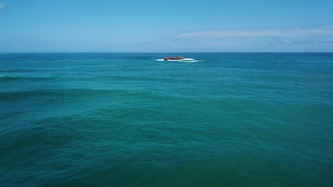하와이 오아후 해안에서 멀리 떨어진 고립되고 작고 바위가 많은 섬을 향해 날아가는 드론