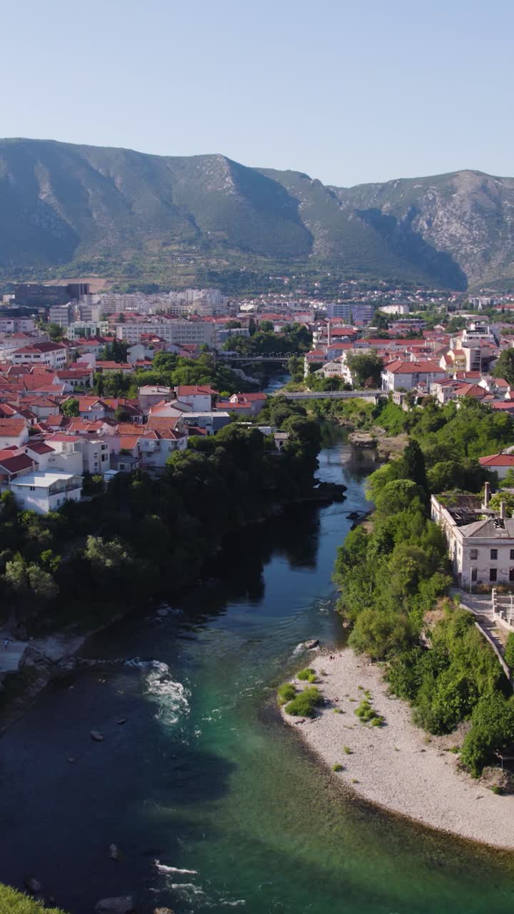 Aerial view of the Neretva River flowing through Mostar, with the Koski Mehmed Pasha Mosque visible on the right bank. Push Forward, Vertical Video