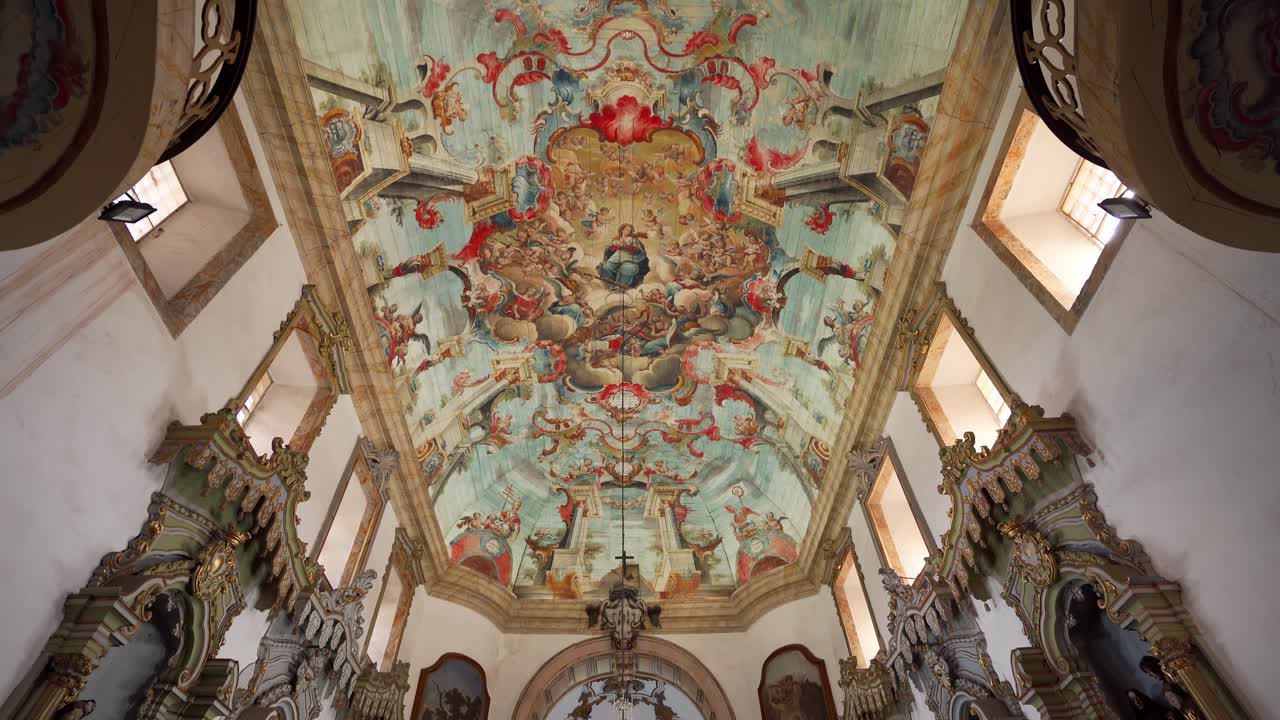 Wide tilt-down shot revealing the vibrant and intricate religious painting on the ceiling of the Church of Saint Francis of Assisi in Ouro Preto, Minas Gerais, Brazil (Minas Gerais, Brasil)