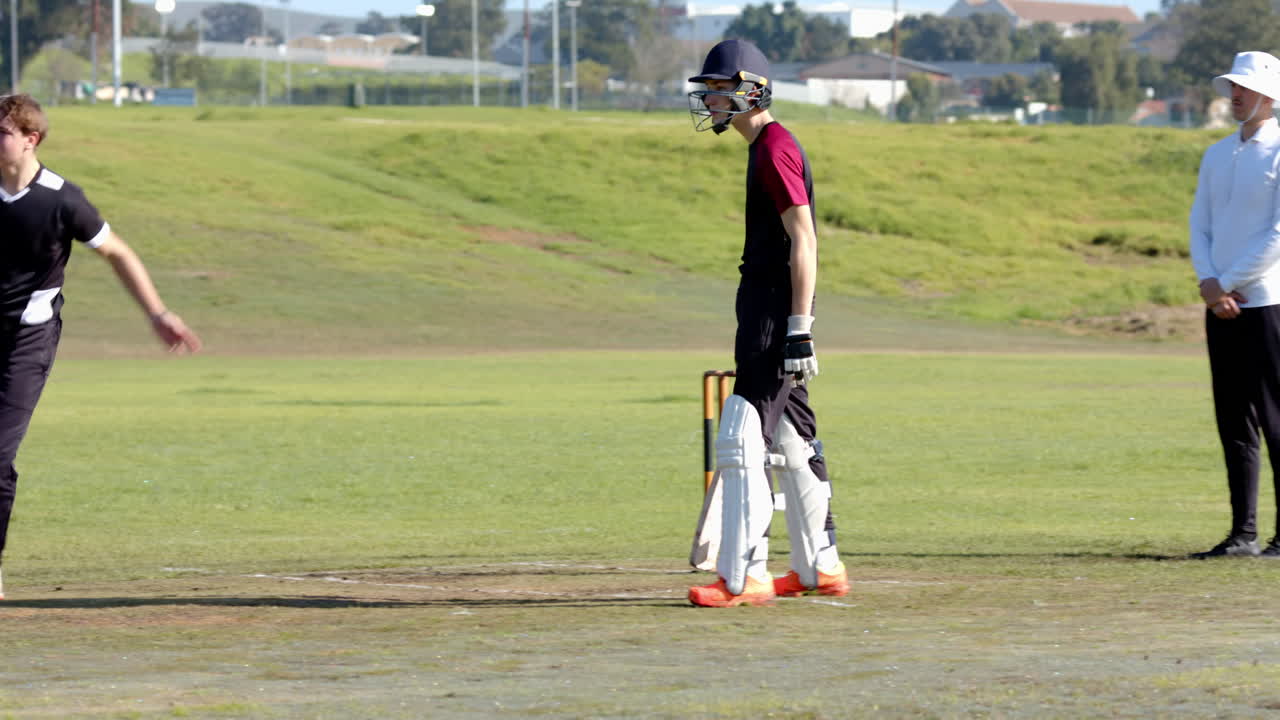 Cricket player running on field, holding bat, wearing protective gear