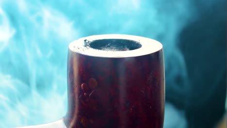 primer plano de una pipa que produce vapor de humo completamente cubierta en un entorno humeante quemando tabaco en interiores en estilo antiguo fondo negro