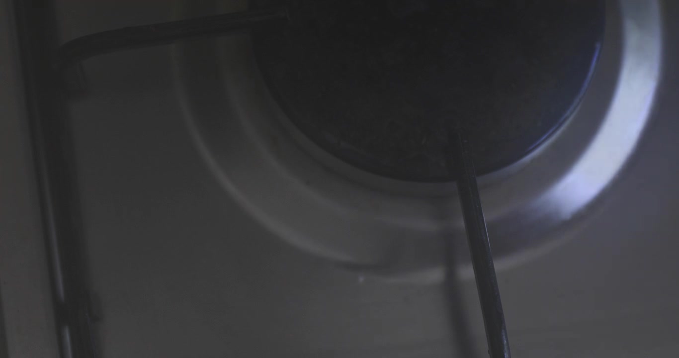 Platzieren einer antihaftbeschichteten Edelstahlpfanne über einer ausgeschalteten Gasflamme.
