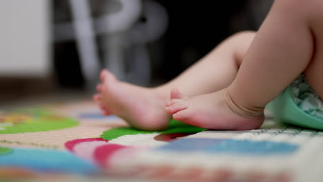 caucasian child lies on back bent in knees. close up of tiny baby feet moving slowly. blurred backdrop.