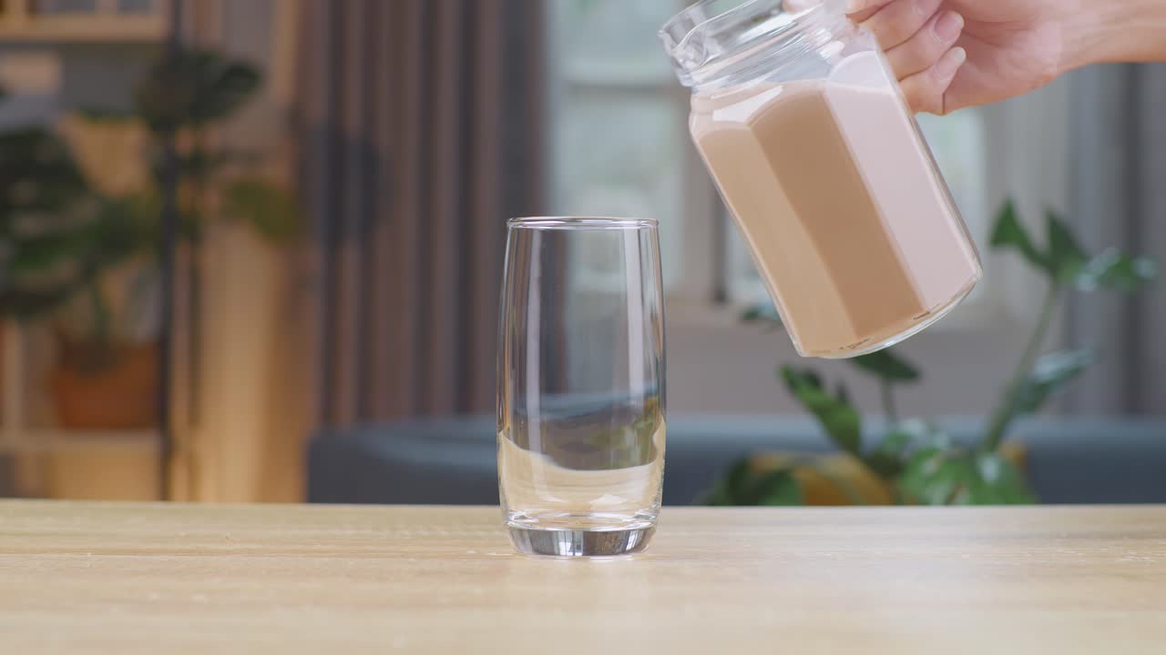 Versamento al rallentatore di latte al cioccolato in un bicchiere