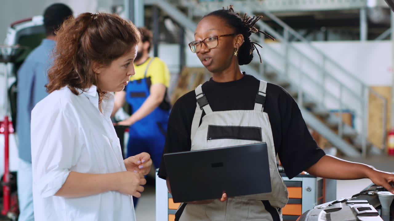 el ingeniero informa a la mujer de los costos de reparación del coche