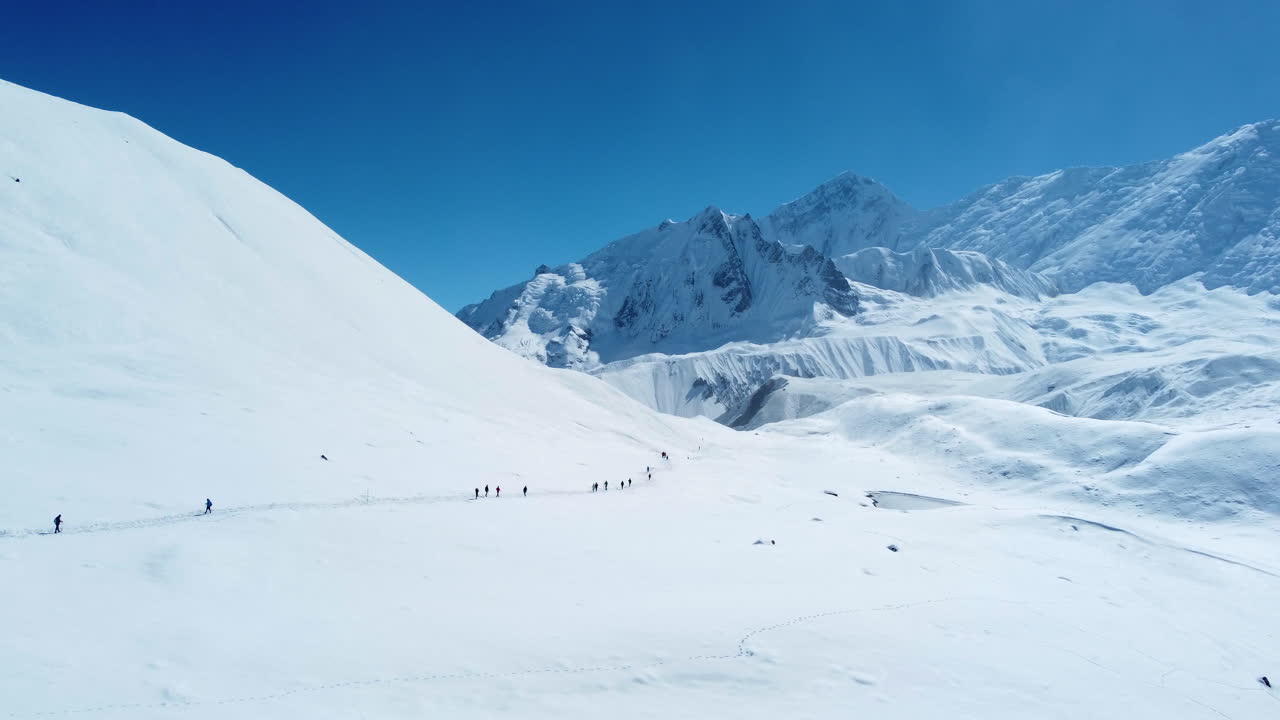 드론은 산으로 둘러싸인 눈  ⁇ 인 땅인 네팔 마 ⁇ 을 돌아다니고 있습니다.