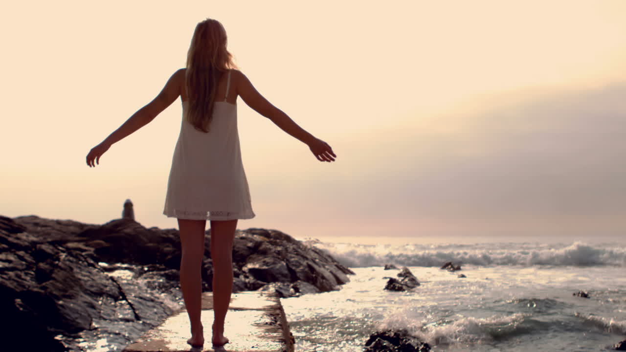 una mujer rubia bonita con los brazos extendidos.