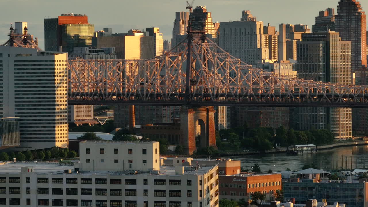 Aerial view of the Queensboro Bridge at sunrise. Shot along the East River with Roosevelt Island and Manhattan in the background