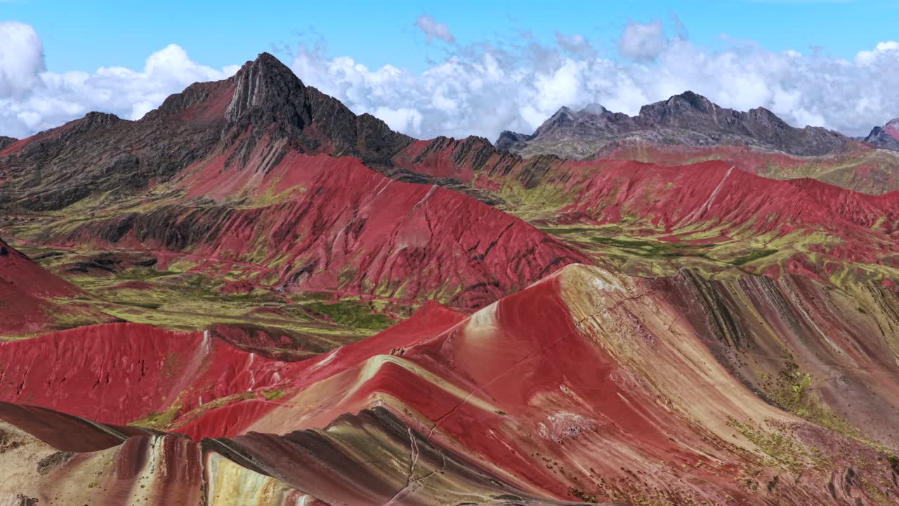 Rainbow Mountain Vinicunca Peru Perú aerial drone Cusco Region morning blue sky Montaña de Siete Colores Palccoyo clouds Peruvian Andes Red Valley striped hills seven colored backwards motion