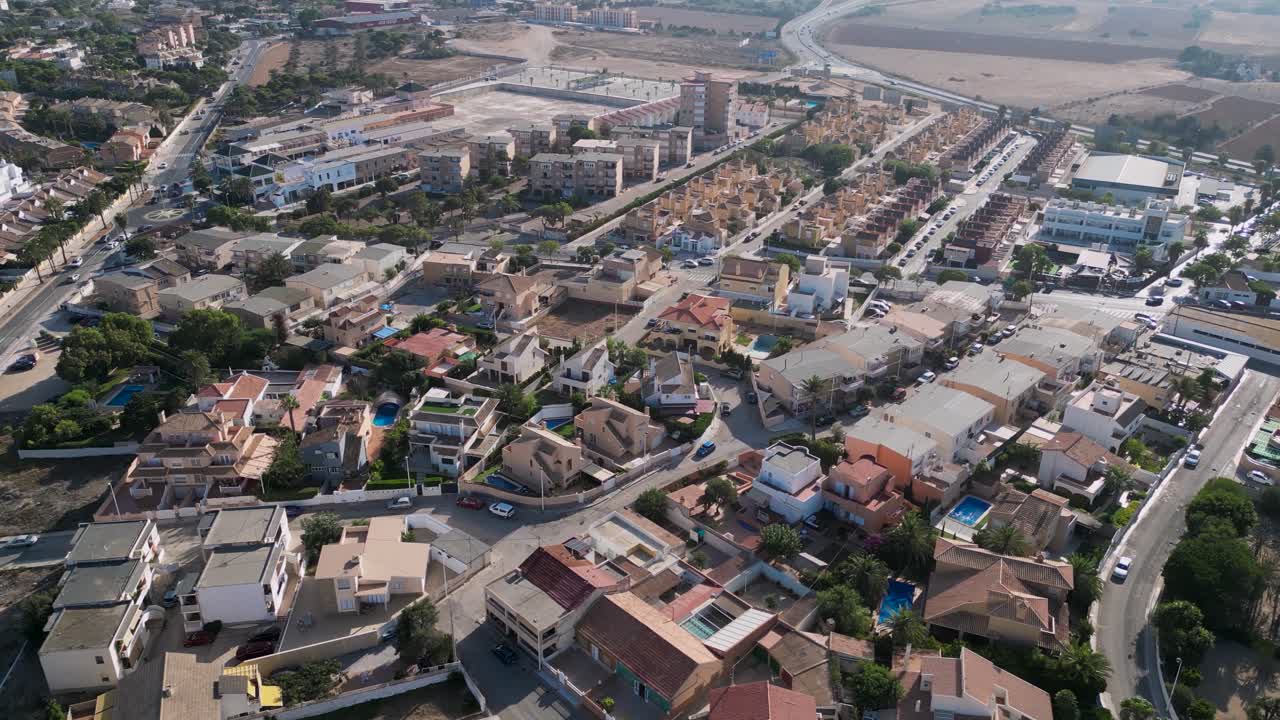 Aerial tilt up view of houses in the touristic Cabo de Palos town, during a sunset time in Spanish summer - Spain