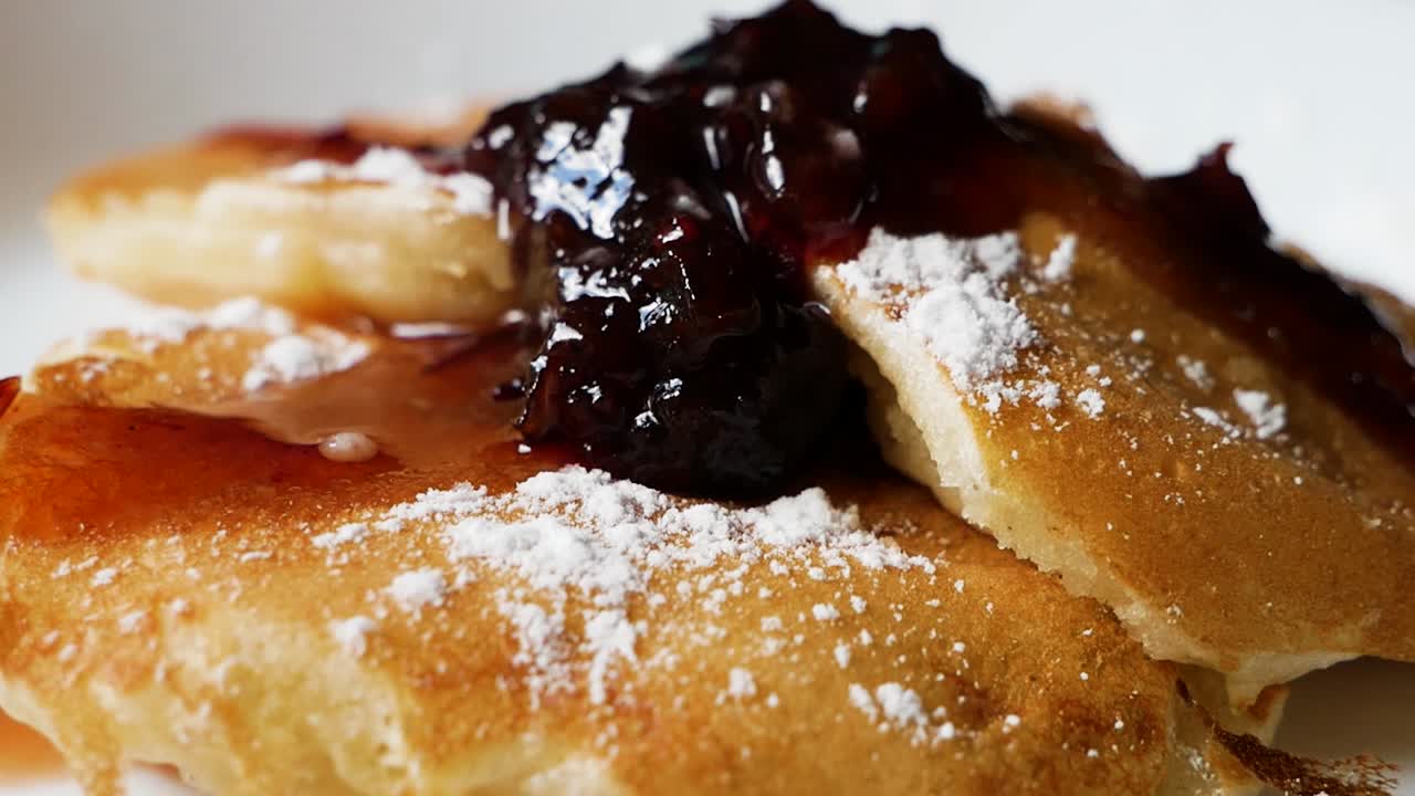 Tasty American Pancakes With Raspberries Jam on top in macro close up handheld shot with camera movement