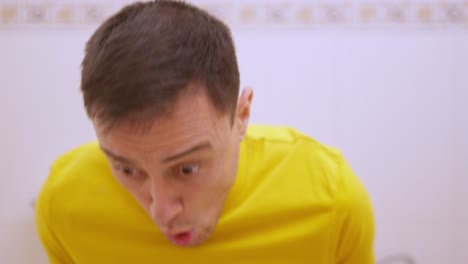 man suffering from diarrhea while sitting on toilet