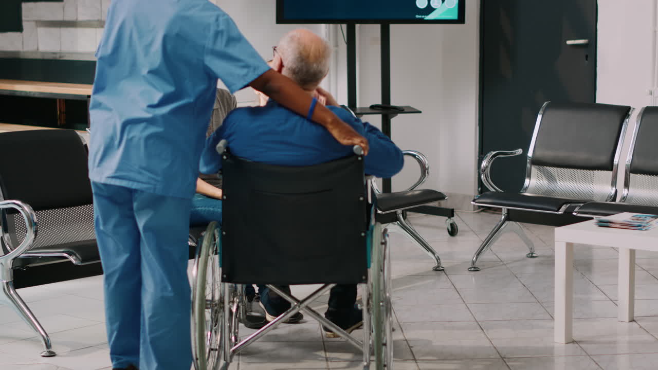 Old person in wheelchair meeting with people in hospital waiting area