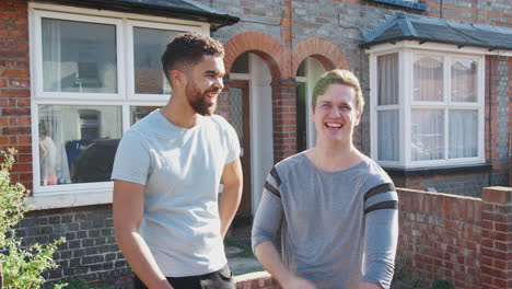 Portrait-Of-Two-Men-Standing-Outside-New-Home--Giving-Each-Other-High-Five