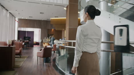 businesswoman walking through hotel lobby