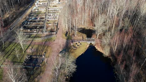 establishing shot and aerial view of gärdsåsmosse natural parkland in bergsjön, gothenburg, sweden - drone shot during afternoon late winter early spring - people walking in nature park in europe