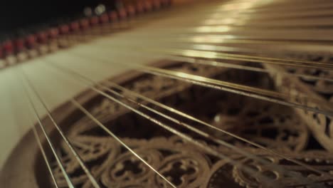 grand piano strings, no camera movement, closeup, slow motion, yellow wood, dark