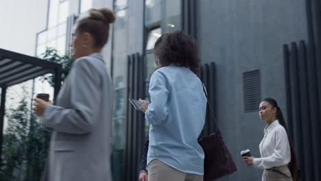 smiling woman using tablet computer in downtown district. corporate people going