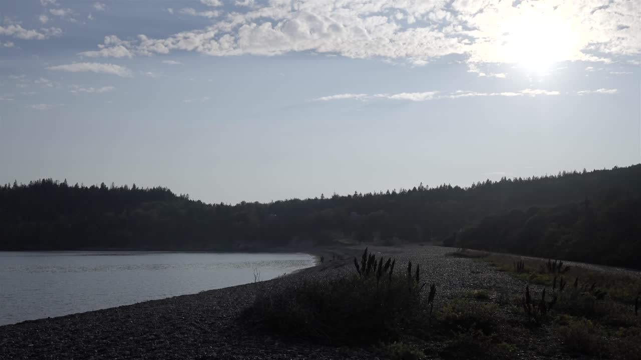Calm and serene pebble shoreline of Jasper Beach in Maine on a hazy sun day