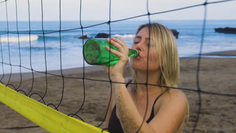 mujer joven bebiendo en la playa.