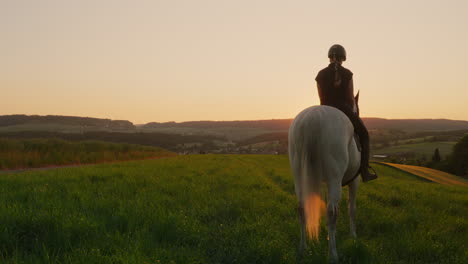 a rider and her white horse enjoy the sunrise