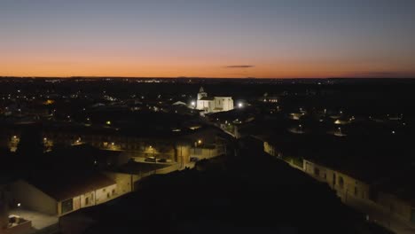 antena aérea de barrio residencial iluminada por las luces de la calle al atardecer