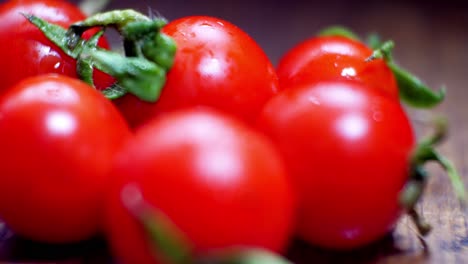 Tomates-Cherry-Mojados-Jugosos-Rojos-Diminutos-Frescos-Crudos-En-La-Superficie-De-La-Cocina-De-Madera-Enfoque-Selectivo-Dolly-Izquierda-Cerrar