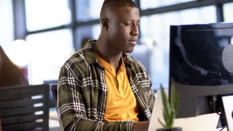 hombre de negocios afroamericano usando computadora en la oficina, cámara lenta, espacio de copia