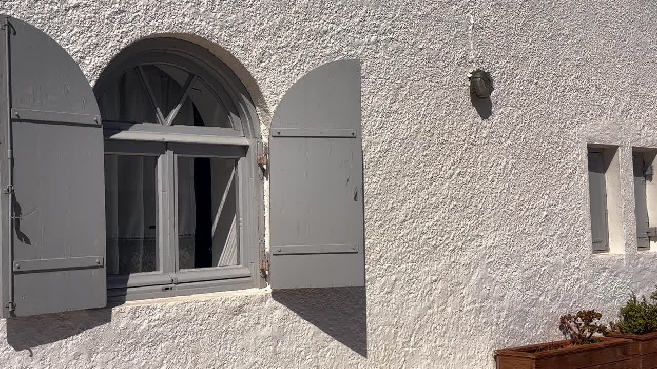 traditional arched window with grey shutters on a whitewashed house in Crete Greece