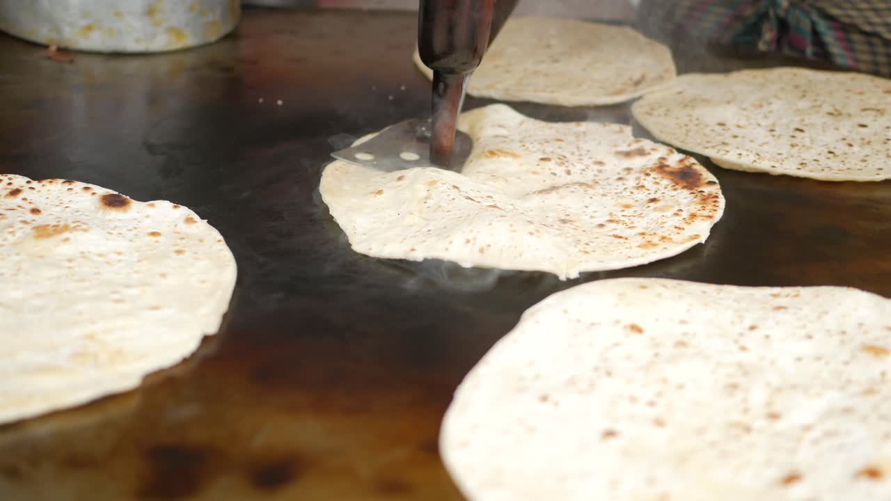 cocinando roti chapati en una sartén grande ,