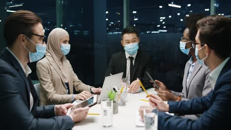 Grupo-De-Empresarios-Multiétnicos-Con-Máscaras-Médicas-En-Una-Reunión-De-Equipo-En-Una-Oficina-Moderna-Y-Discutiendo-Sobre-Un-Proyecto-2