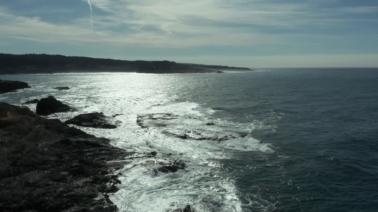 Ripresa aerea sull'oceano che vola bassa all'indietro verso la riva.