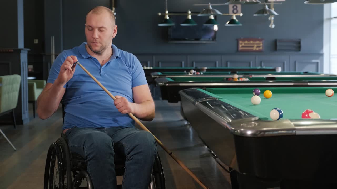 hombres adultos con discapacidad en silla de ruedas juegan al billar en el club