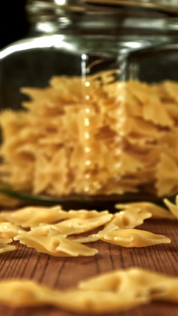 Slow Motion of Farfalle Pasta Falling on Wooden Table