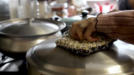 las ollas de cocina en una estufa, las personas levantando las tapas y mezclando ingredientes en medio de vapor giratorio, encarnando la esencia del arte culinario y la gastronomía