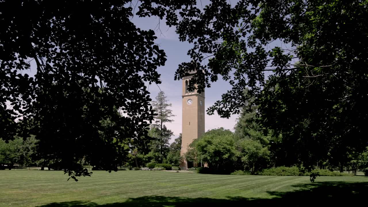 Campanile Stanton Memorial Carillon nel campus della Iowa State University ad Ames, Iowa con ripresa con gimbal che avanza tra gli alberi