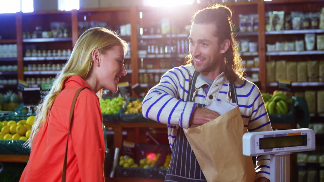 personal masculino ayudando a la mujer a seleccionar verduras