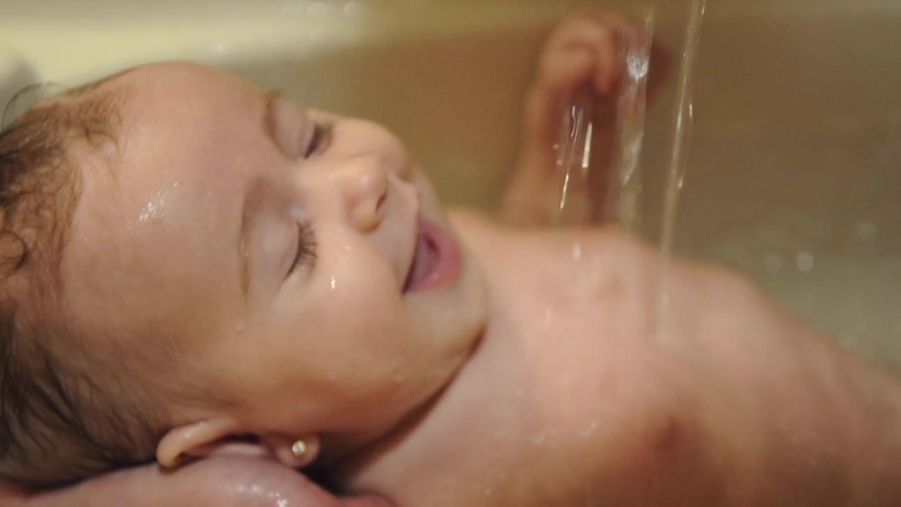 Father bathing his little baby in bathtub
