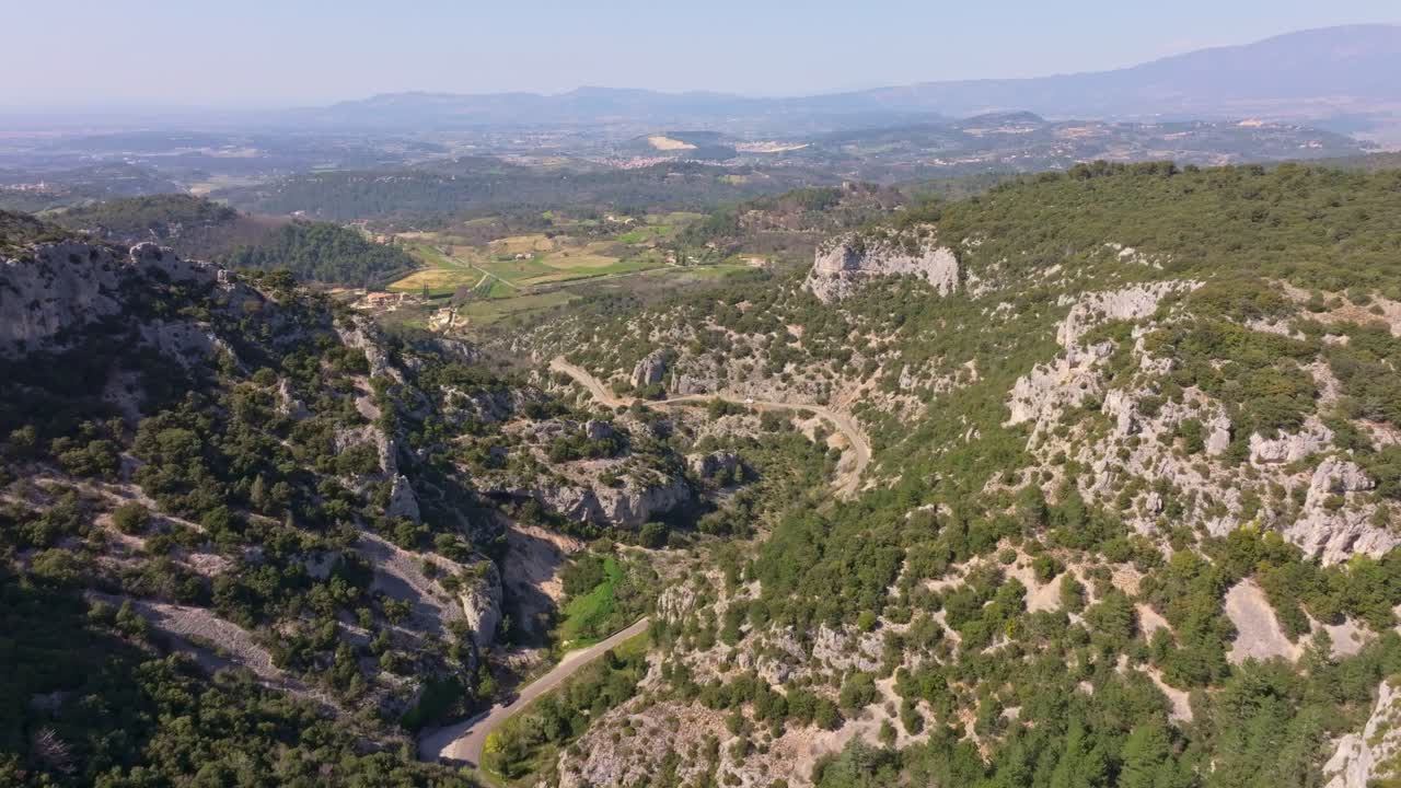 Vista aerea di una singola auto rossa che percorre curve di montagna vicino a Venasque