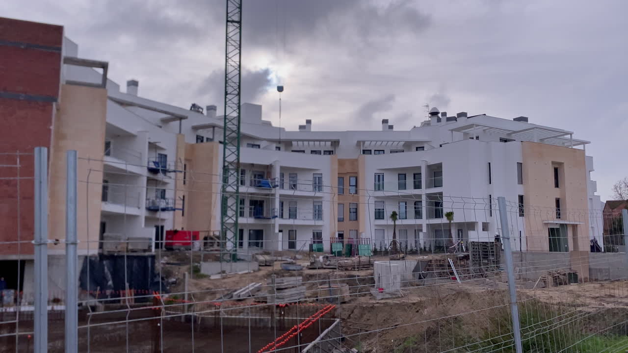 Nuovo sviluppo residenziale in corso con gru e strutture in cemento. Crescita edilizia e infrastrutture a Sanlucar de Barrameda.